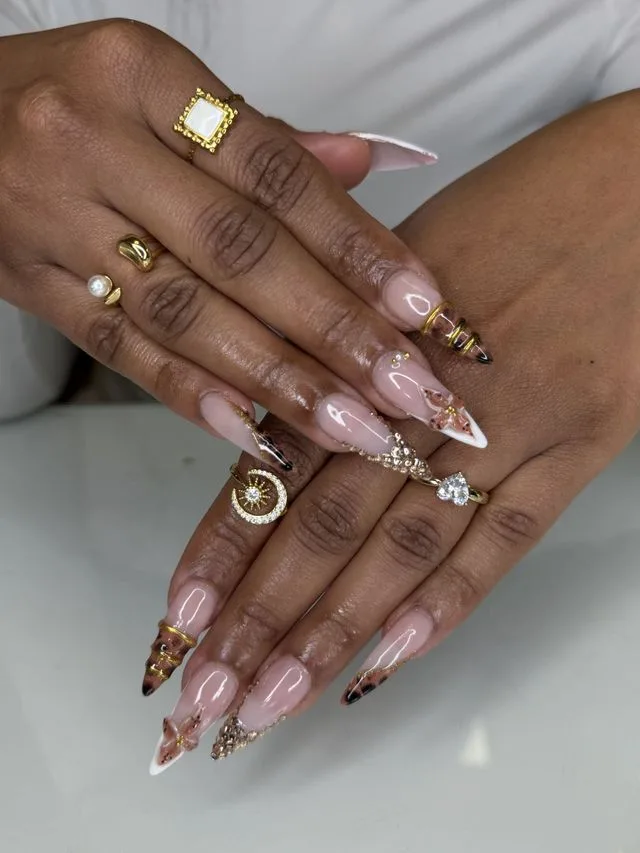 Nail art amande avec papillons, strass et bijoux dorés